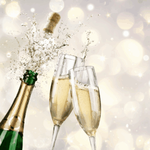 Photo of a champagne cork popping and two champagne flutes