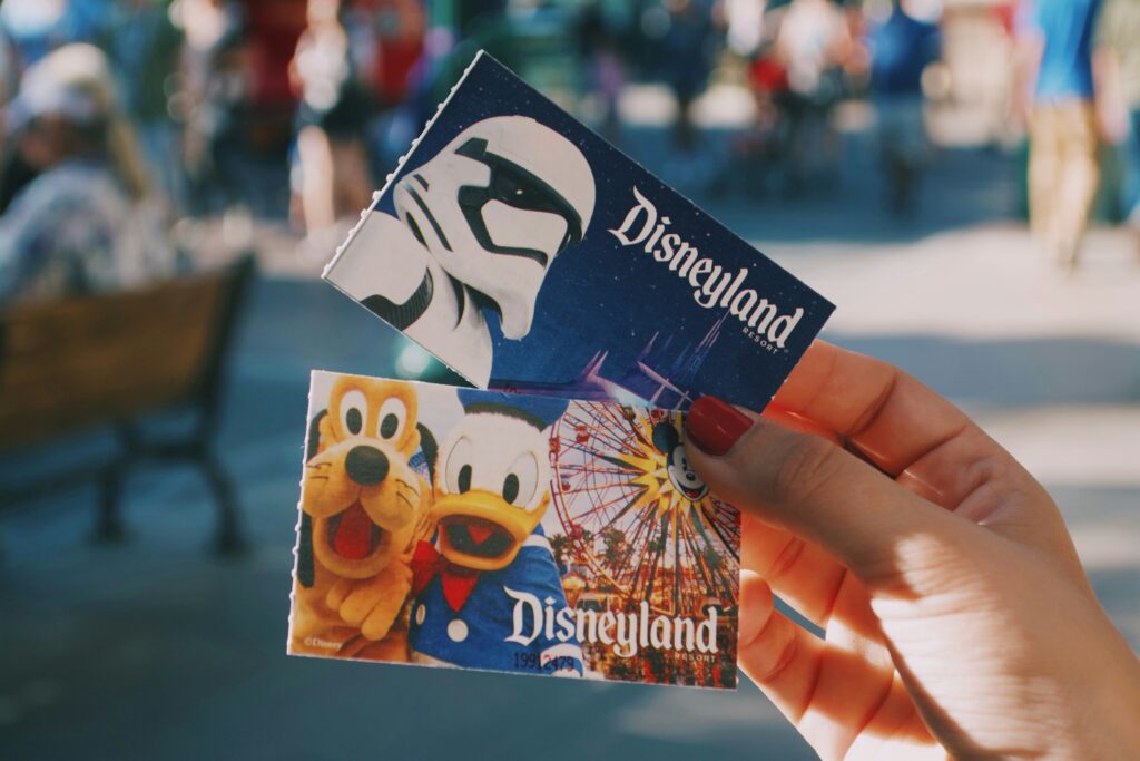 A photo of someone's hand holding Disney tickets
